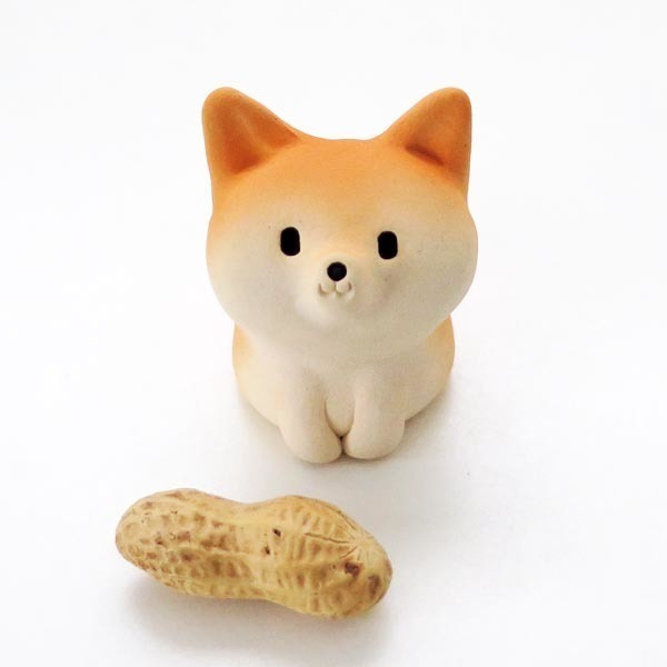 Small shiba inu figurine and a peanut